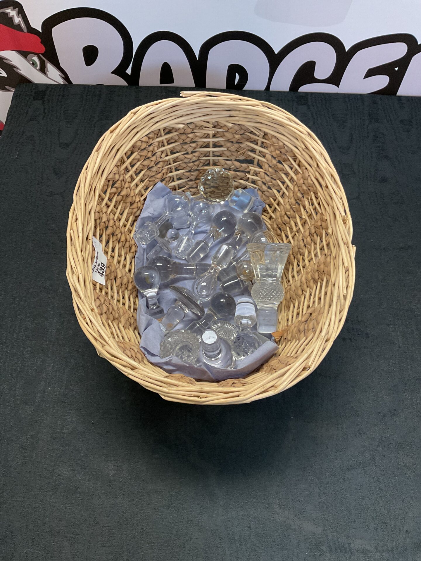 439 Crystal decanter stoppers in wicker basket