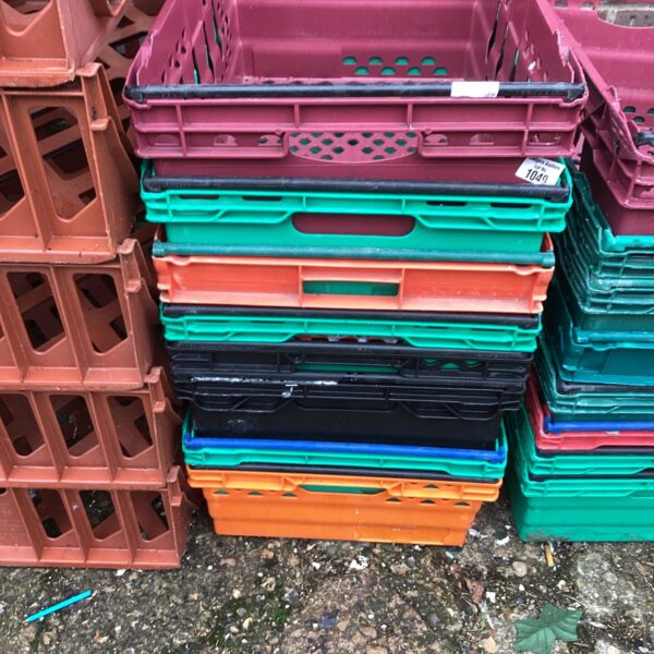 Lot of eight used plastic storage crates for garage or workshop.