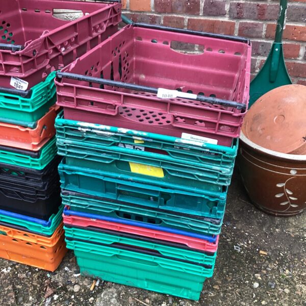 Stack of colourful plastic storage crates for garden or home use.