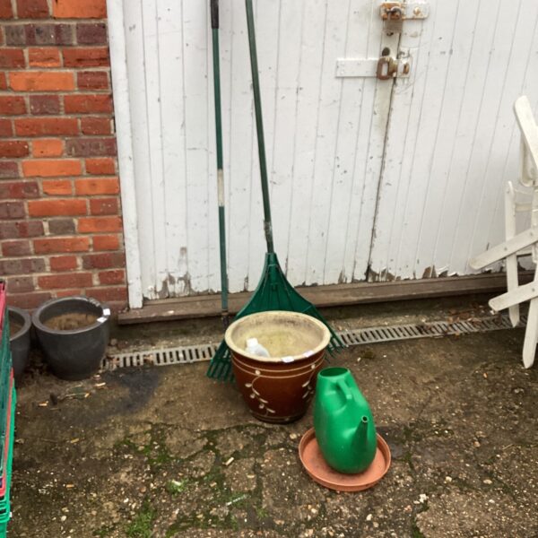 Vintage garden tools and terracotta planter for outdoor use.
