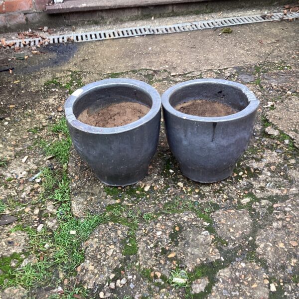 Two weathered terracotta garden planters for outdoor use.