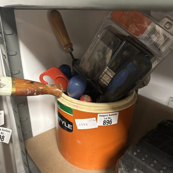 Assorted hand tools in a plastic pot for DIY projects.