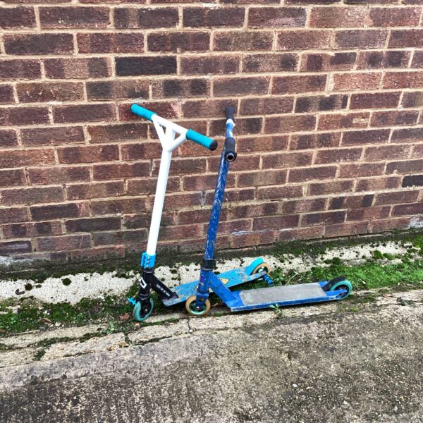 Two colourful stunt scooters displayed side-by-side.