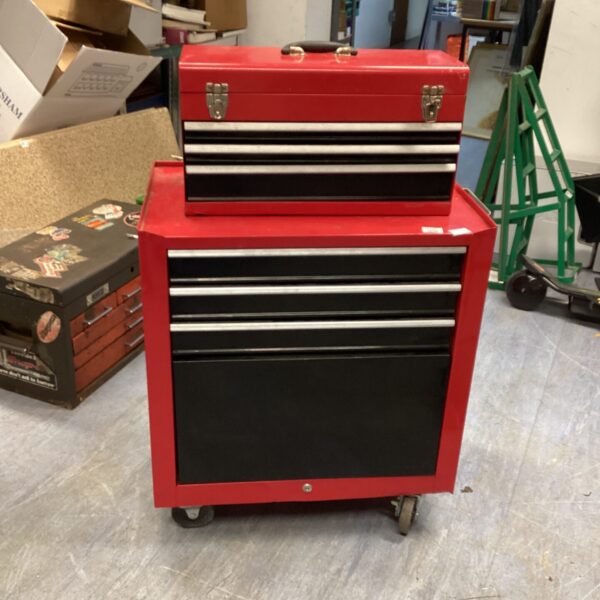 Red metal tool chests with drawers on casters for workshop storage.