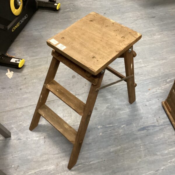 Vintage wooden step ladder with two steps, rustic and weathered.