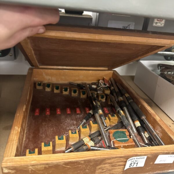 Vintage micrometer calibration rods in a wooden case for precision measurement.