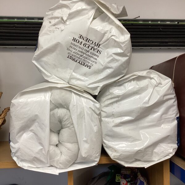 Bundle of three Downland 13.5 tog eco-friendly duvets, showing wear.