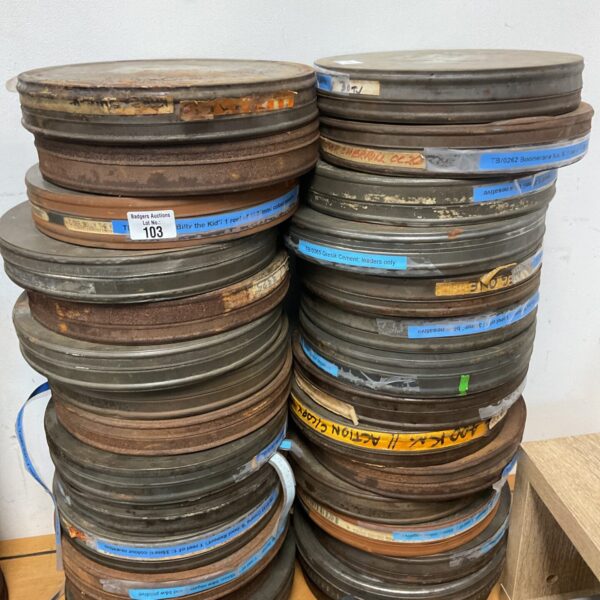 Stack of vintage 35mm movie reels and metal canisters.