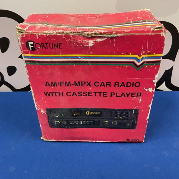 Vintage Fortune car radio with cassette player, side view.
