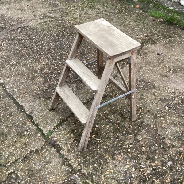 Vintage wooden two-step ladder for garden or DIY tasks.