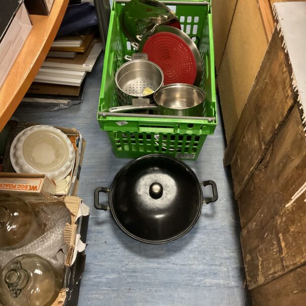 Crate of mixed stainless steel cooking pans and kitchenware.