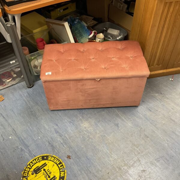 Pink crushed velvet ottoman with storage, ideal for home decor.