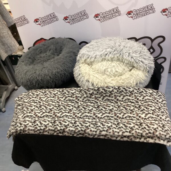 Two soft pet beds with a fleece blanket on display.