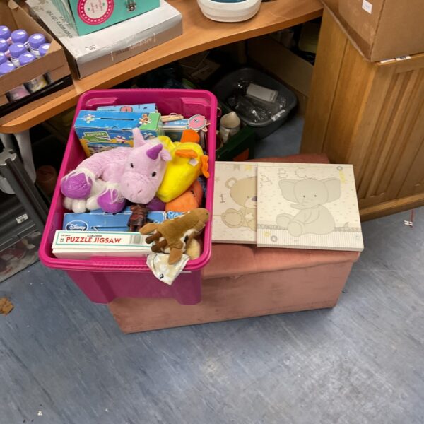 Mixed toy lot with assorted games and plush toys inside a container.