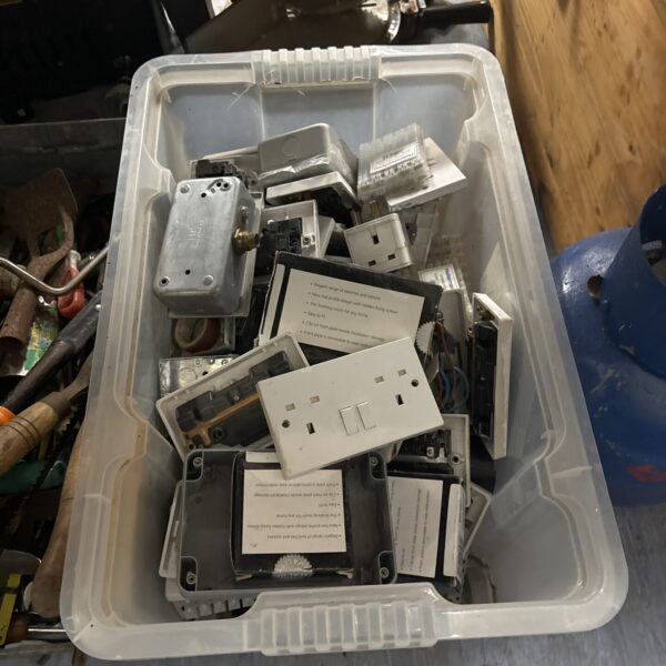 Assorted vintage and modern wall sockets in a storage box.