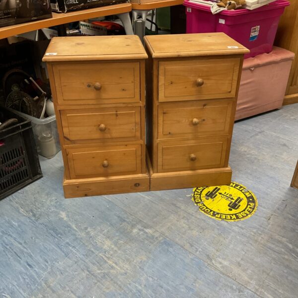 Two vintage pine bedside cabinets with three drawers.