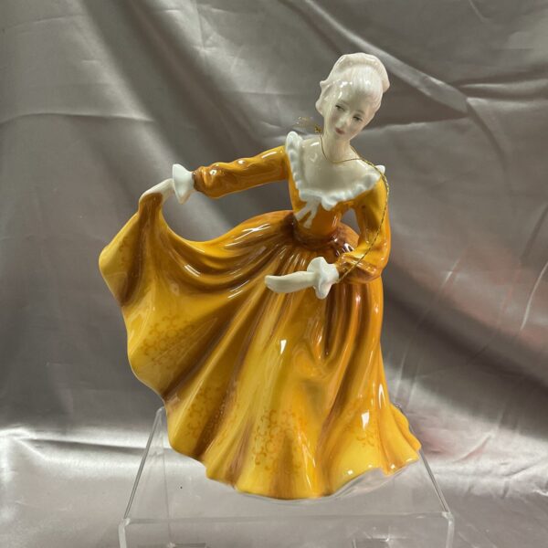 Vintage Royal Doulton Kirsty figure in golden gown, collectible porcelain.