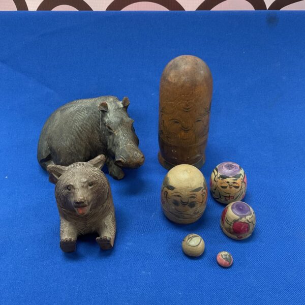 Antique carved wooden figures including a Russian doll and bear.