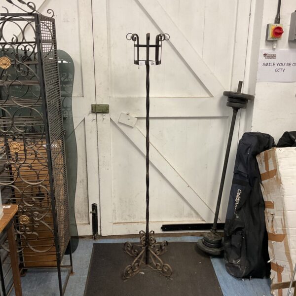 Ornate wrought iron church candle holder with multiple arms.