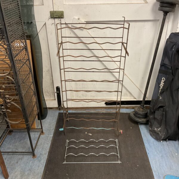 Vintage metal wine rack for storing wine bottles.