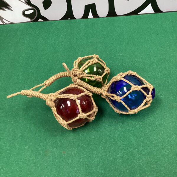 Three colourful vintage glass fishing net floats with netting.