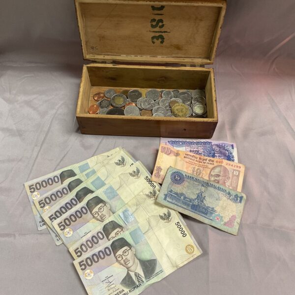 Assorted world coins and banknotes in a box, including Malaysian Ringgit.