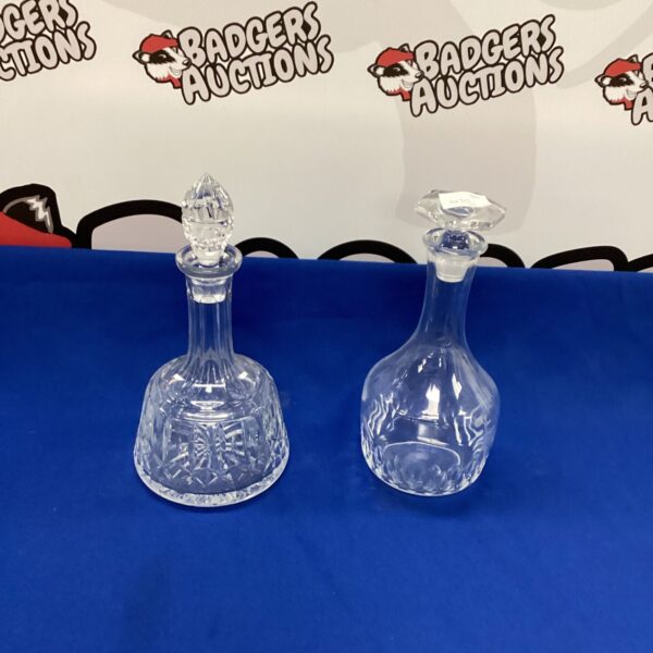 Two vintage crystal decanters with cut glass detailing.