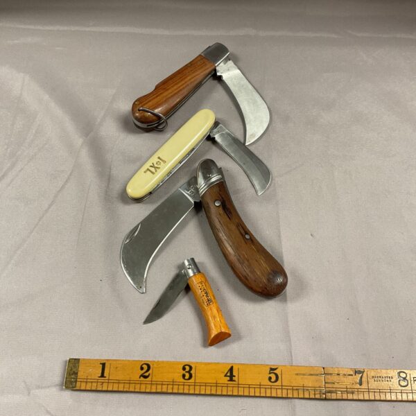 Lot of four vintage garden pruning knives with wooden handles.