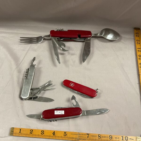Lot of four vintage multi tool pocket knives with red handles.