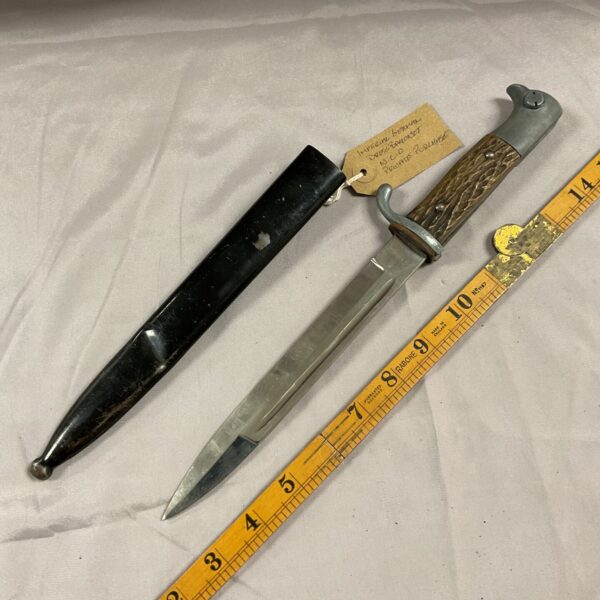Antique German dress bayonet with dark wood grip and steel blade.