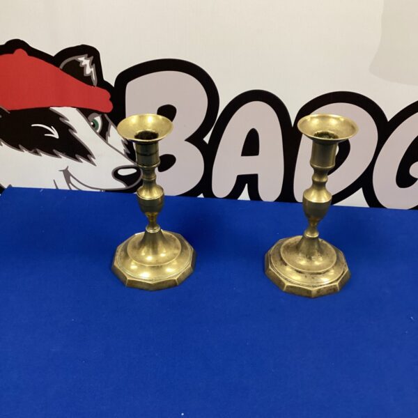 Pair of vintage brass candle holders on a dark surface.