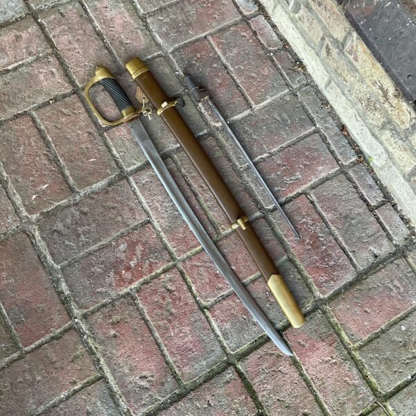 Full view of replica Russian Cossack sword on brick surface.
