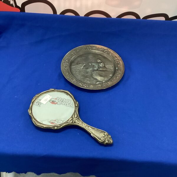 Vintage hand mirror with pewter plate and decorative handle.