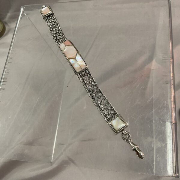 Close-up of a sterling silver bracelet with mother of pearl insets.