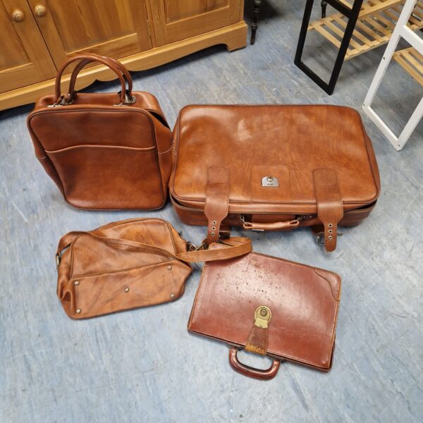 Vintage brown leather luggage set including suitcase and briefcase.