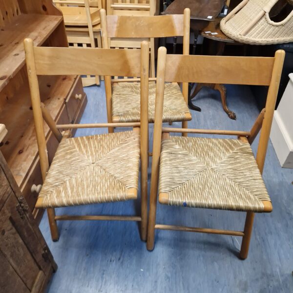 Vintage lot of three folding chairs needing restoration with woven seats.