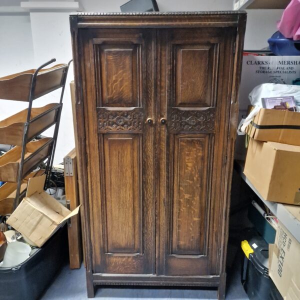 Dark wood vintage wardrobe with decorative panelling.
