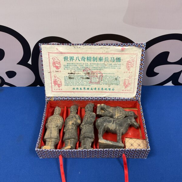 Cased set of miniature Chinese terracotta warriors on display.