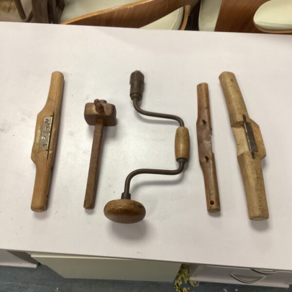 Vintage woodworking tools including butterfly planes and a brace bit.