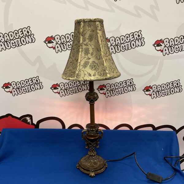 Ornate antique brass table lamp with cream lampshade.
