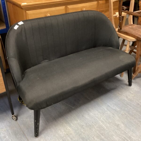 Small black two-seater sofa with vintage mid-century style.
