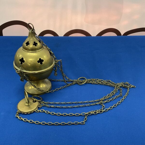 Antique brass thurible censer with ornate detailing and hanging chain.