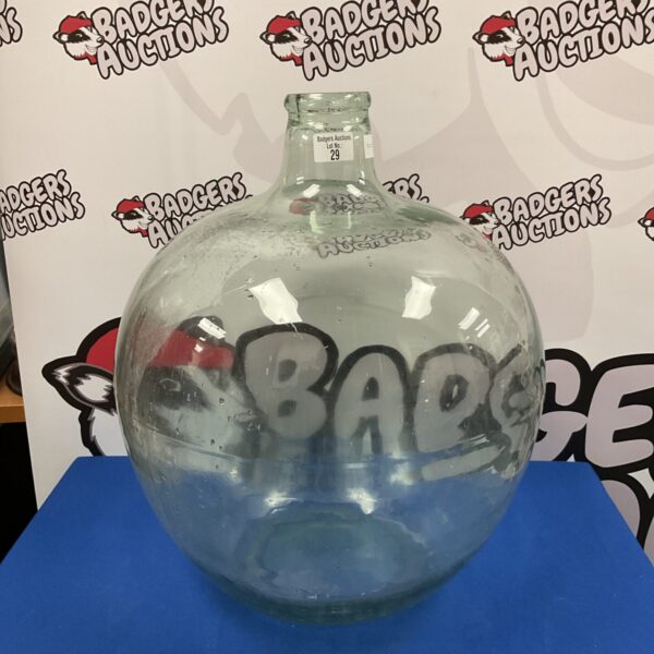 Large glass carboy vivarium with auction branding.