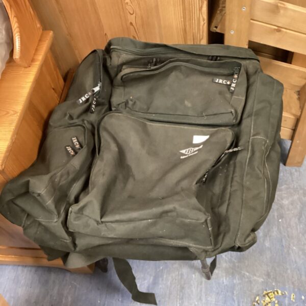 Front view of a well-used JRC fishing bag with multiple pockets.