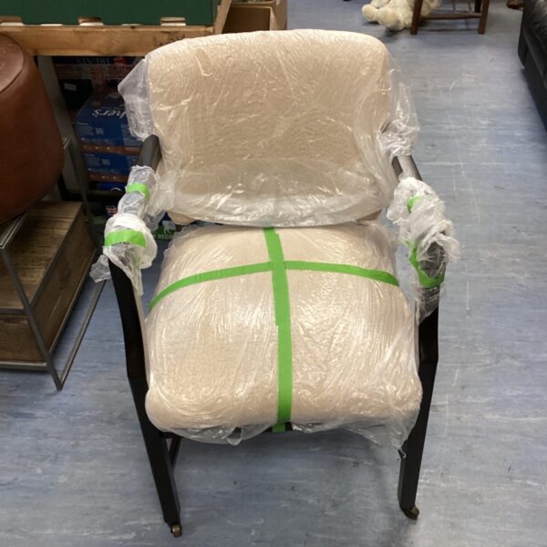 Newly reupholstered armchair with neutral fabric, ready for a home.