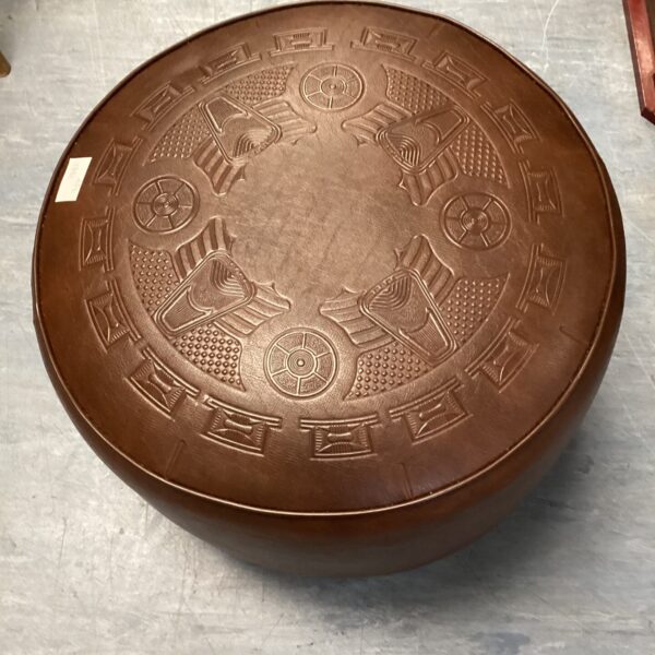 Brown leather foot rest with geometric pattern, vintage mid century style.