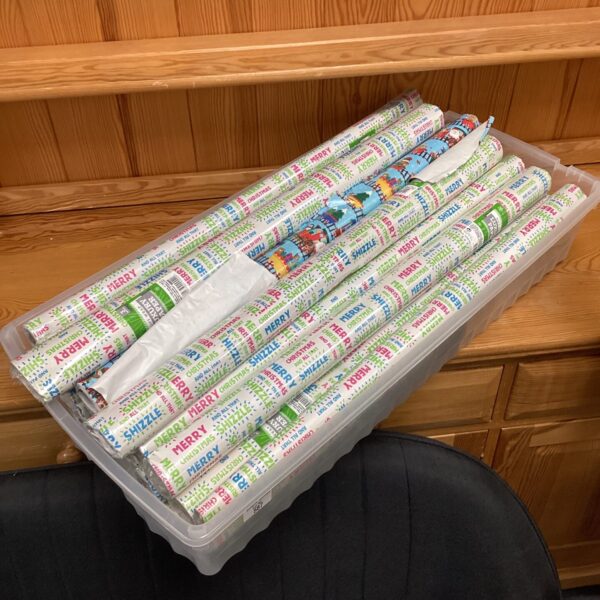 Colourful roll of Christmas wrapping paper with festive tree design.