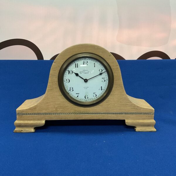 Antique Camerer Cuss mantle clock with brass case and white dial.
