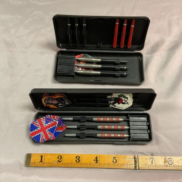 Open case displaying two sets of vintage darts.