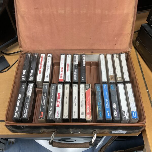 Vintage cassette tape lot in a brown carrying case.
